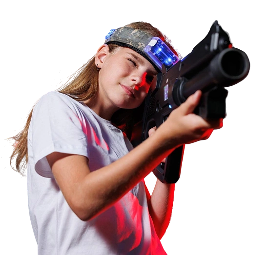 Een jong meisje poseert met een speelgoedlaserpistool en een hoofdband met blauwe ledlampjes, tegen de achtergrond van een effen witte muur.